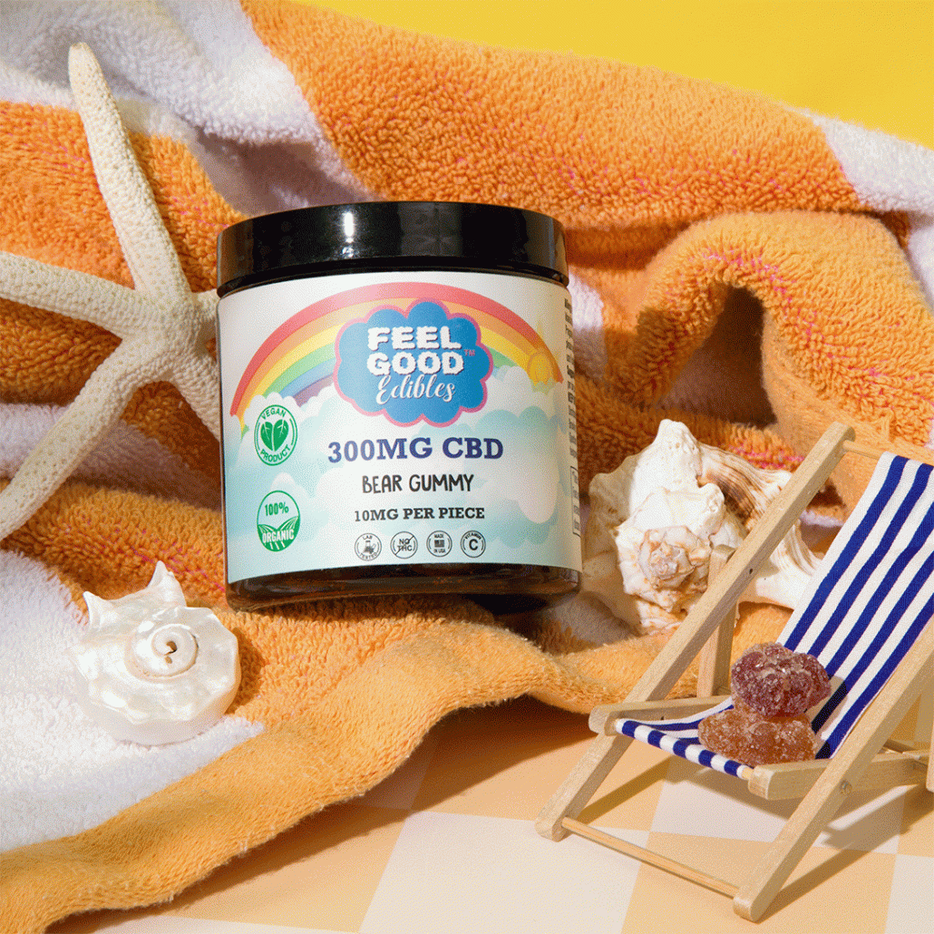 300mg CBD bear gummy container on a towel with seashells and a miniature deck chair holding gummies.