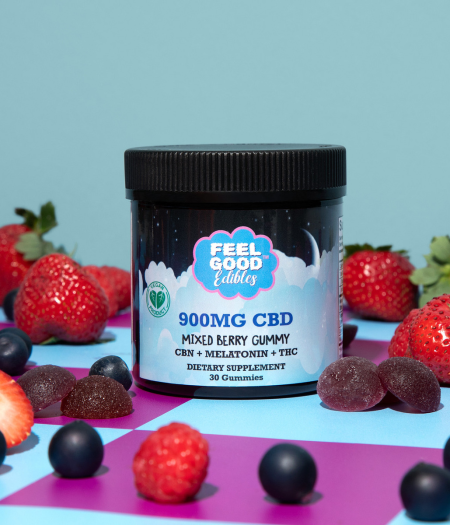 Container of 900mg CBD mixed berry gummies surrounded by strawberries and blueberries on a colorful background.